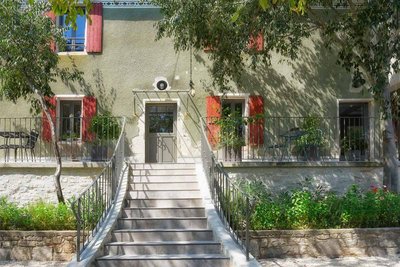 Vue de l'entrée de la maison avec une partie de la cour et du jardin