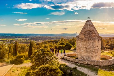 Groupe d'amis au sommet, à proximité d'un moulin, vue sur le Pic Saint-Loup.
